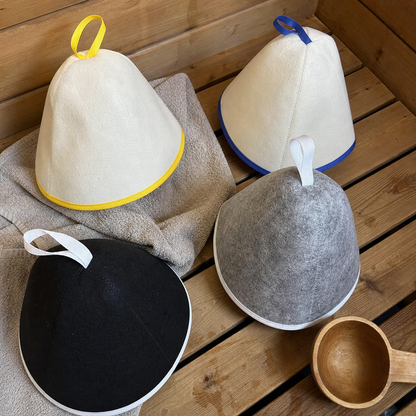 Brand-created UGC-style photo showing four Arctic Nut Banya Hat colorways on a cedar bench