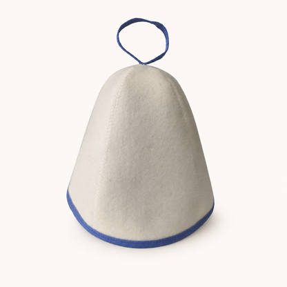 White felt Arctic Nut Banya Hat with blue trim on a plain warm-white background