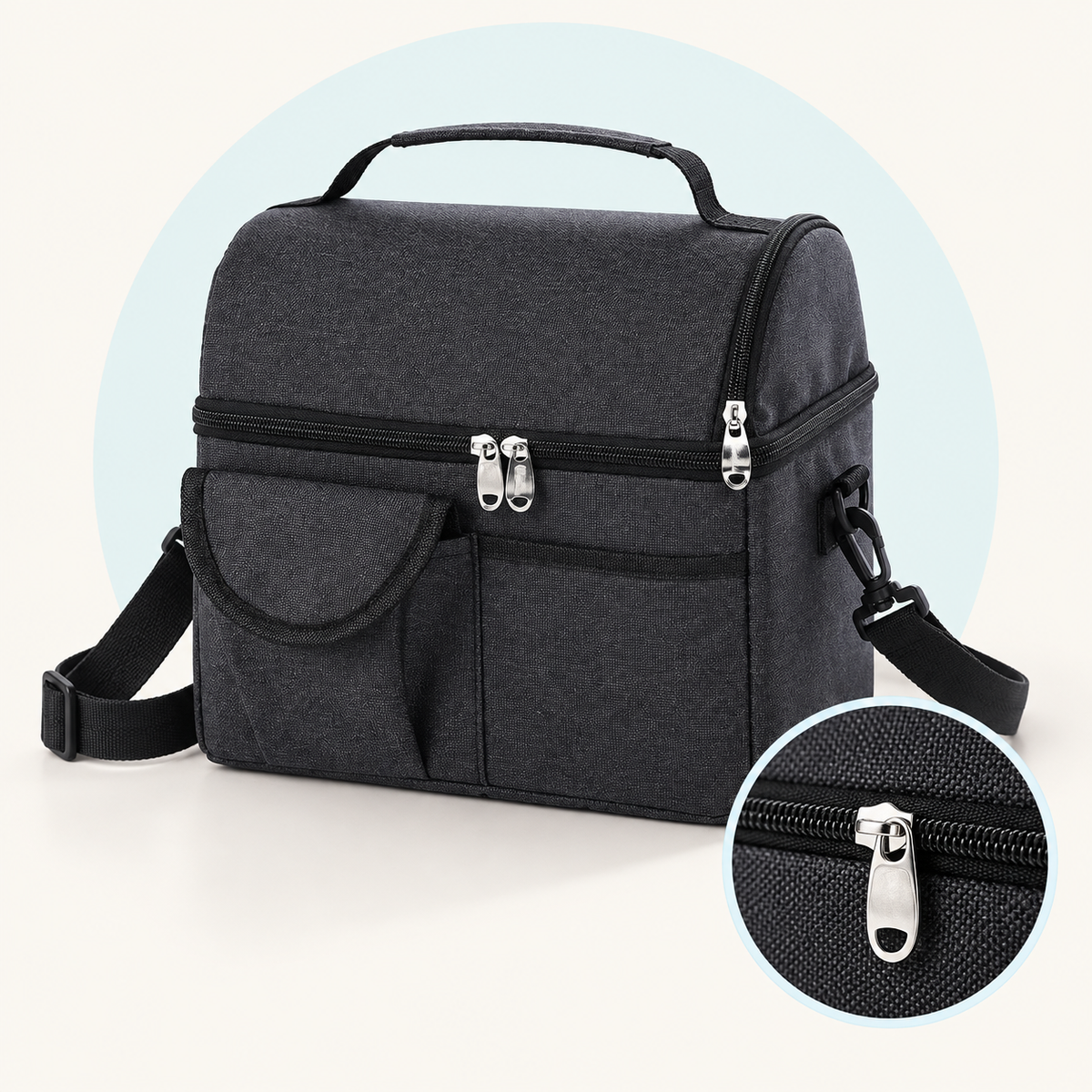 Product study of the black Insulated Carry Bag with two zipped levels, front pockets, handle and shoulder strap, with magnified zipper detail