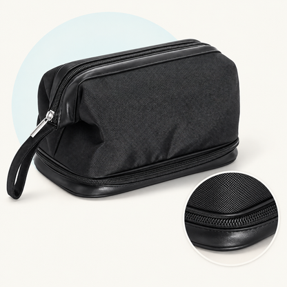 Product study of the black Wash Bag with top zip, wrist strap and separate bottom zip compartment, with magnified lower zipper detail